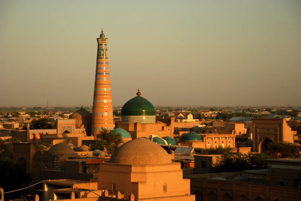 Chiwa – minaret Islam Chodży i kopuły Ichan-Kali o zachodzie słońca